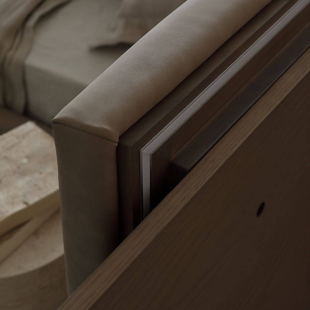 Amorph King Size Bed by Beacon, modern wooden bedsteads with sleek design and natural finish, shown from a side angle.