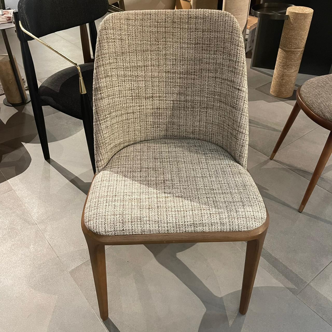 Display of a YOL Living Genova dining chair, showcasing its modern design and wooden frame, used as a showroom display piece.