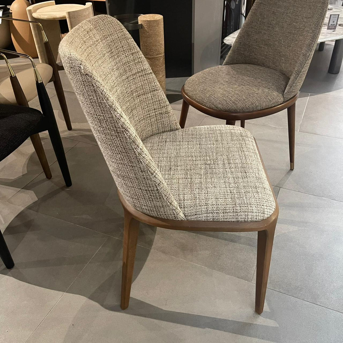 Display of a Genova dining chair by YOL LIVING, showcasing the chair's modern design and wooden legs.