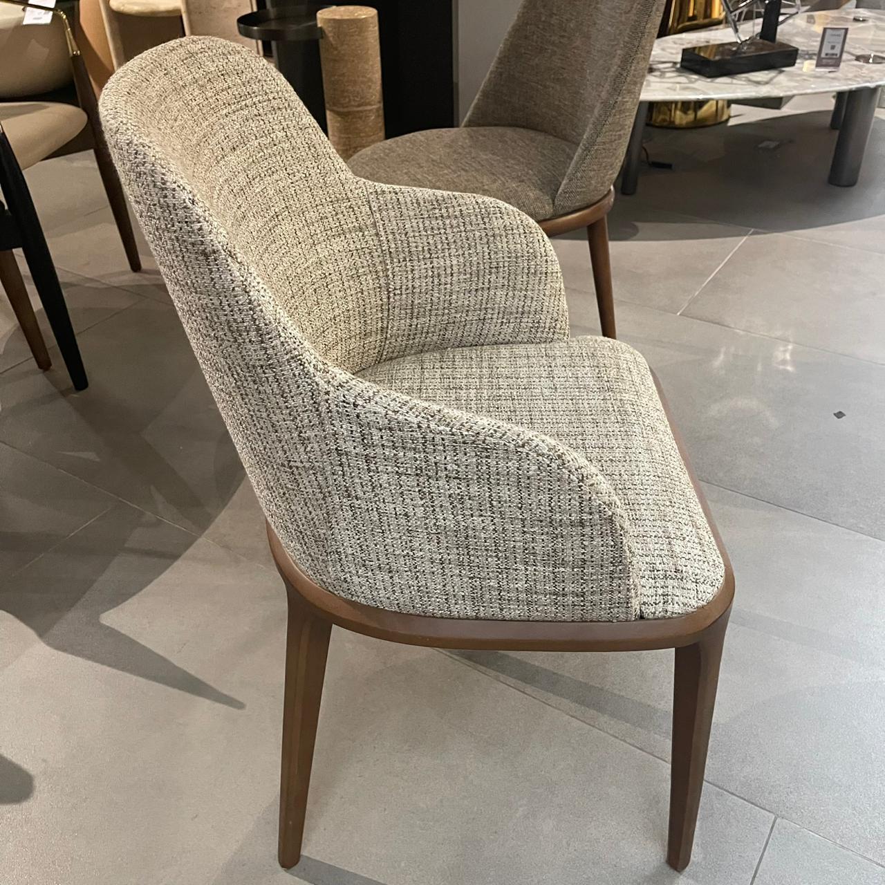 Display of a Genova dining chair with armrests by Yol Living, showcasing its stylish design and armrest details.