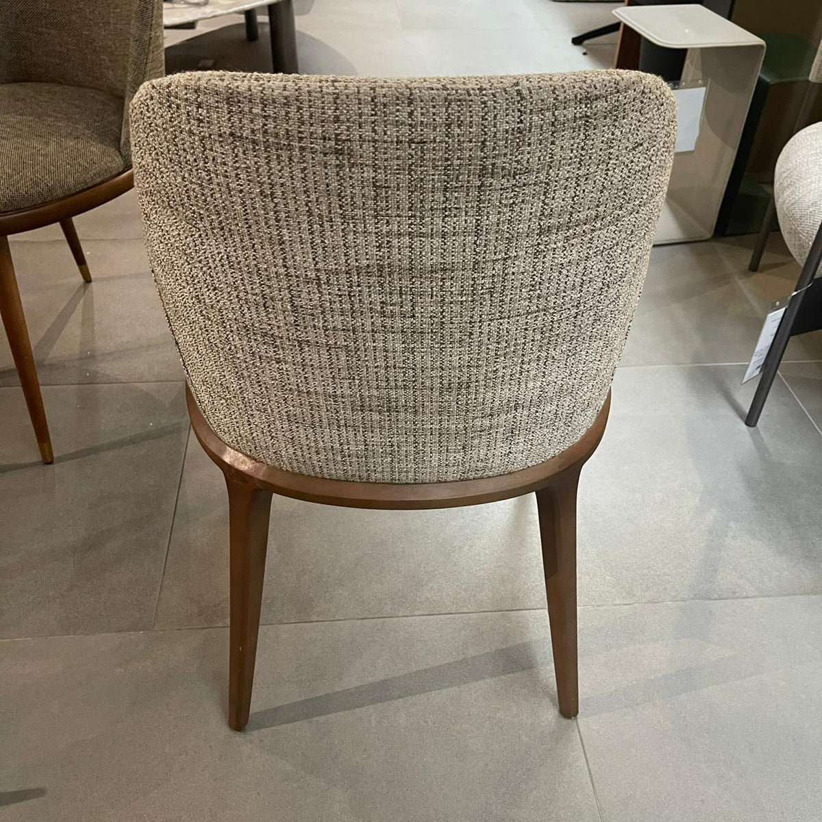 Genova dining chair with arms by YOL LIVING, showcasing a modern design and wooden frame, displayed as a store model.