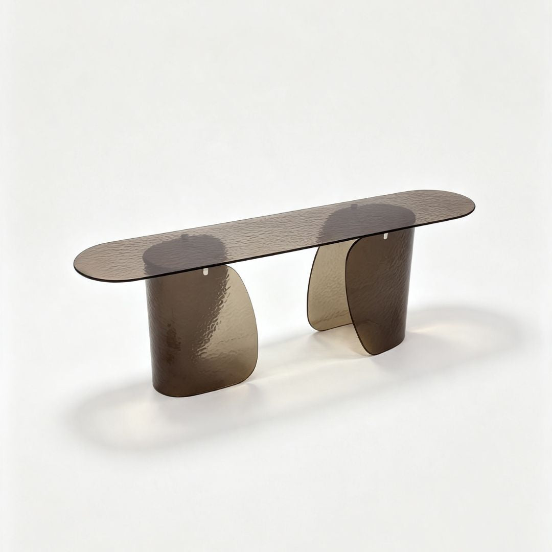 A modern translucent smoked glass console table with a rounded rectangular top and two sculptural curved legs, shown on a clean white studio background.