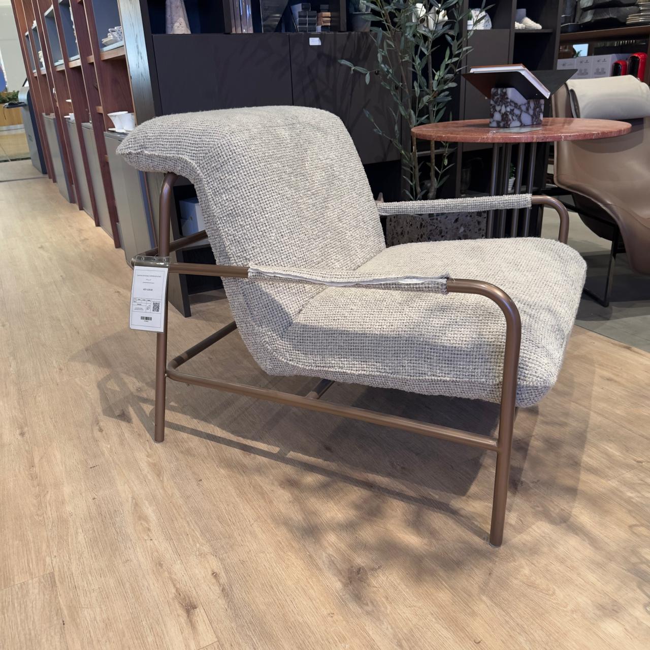 Display of the Gamma Armchair by HOMAGE KOLTUK, showcasing its modern design and plush fabric in a stylish living room setting.