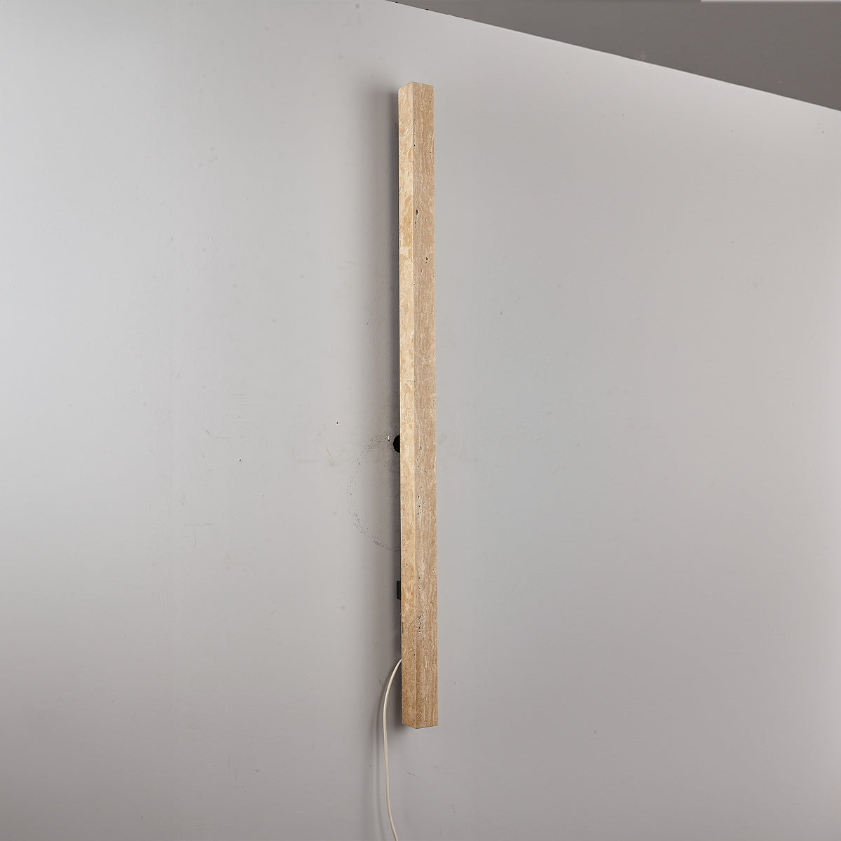 Beige natural travertine marble wall lamp by BEACON, featuring a sleek design with warm illumination for modern interiors.