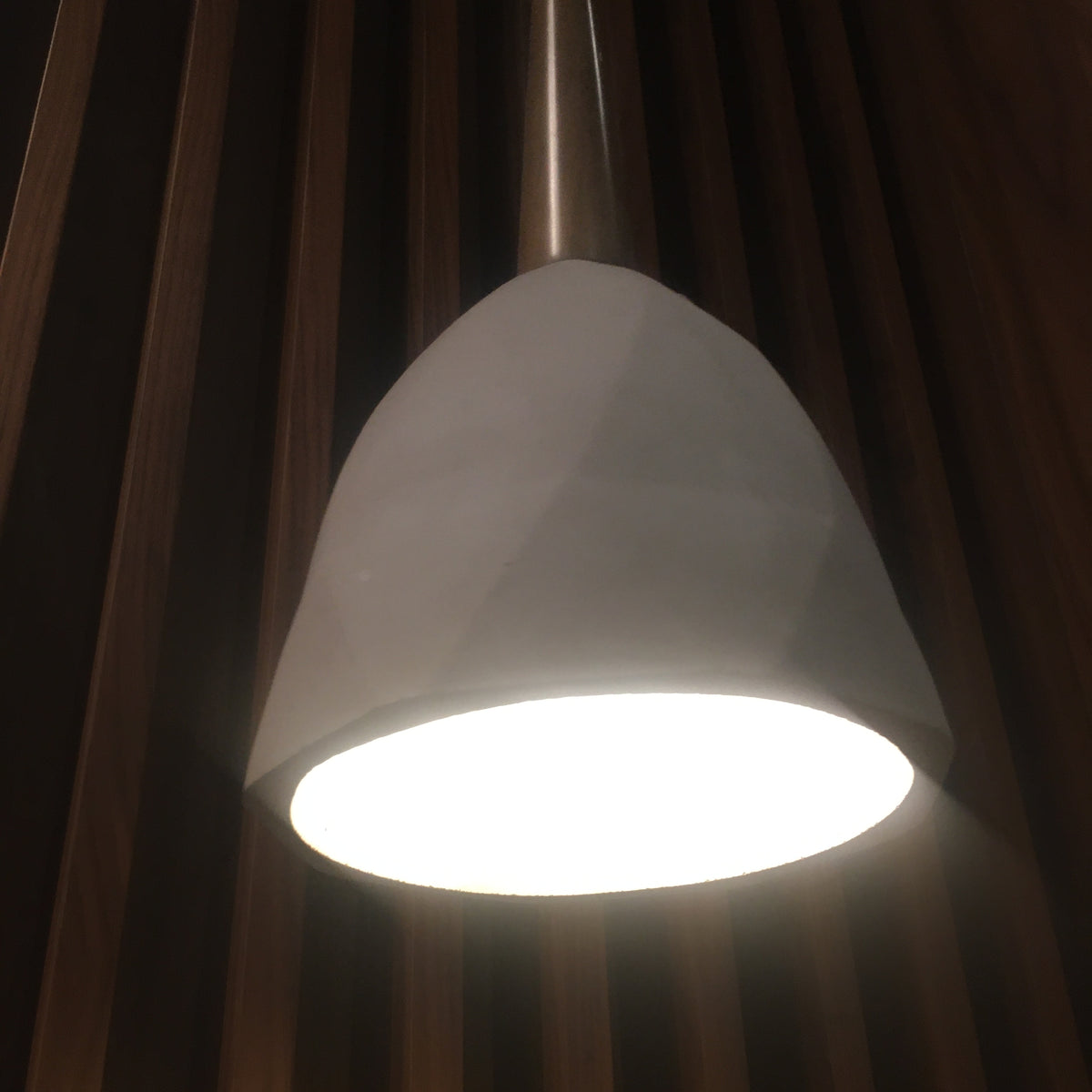 Large convex concrete and wood lamp display item by Beacon with a modern, textured design and a sleek wooden base.