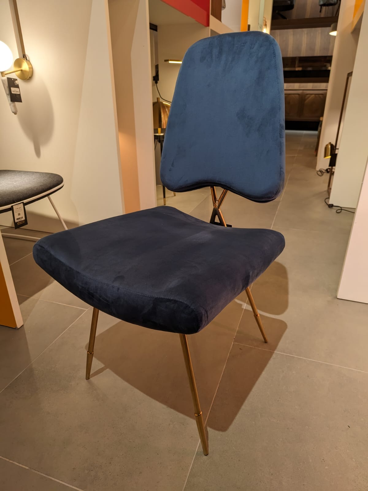Display of a Velletri Cross dining chair by Beacon, showcasing the chair’s elegant design and wooden frame.