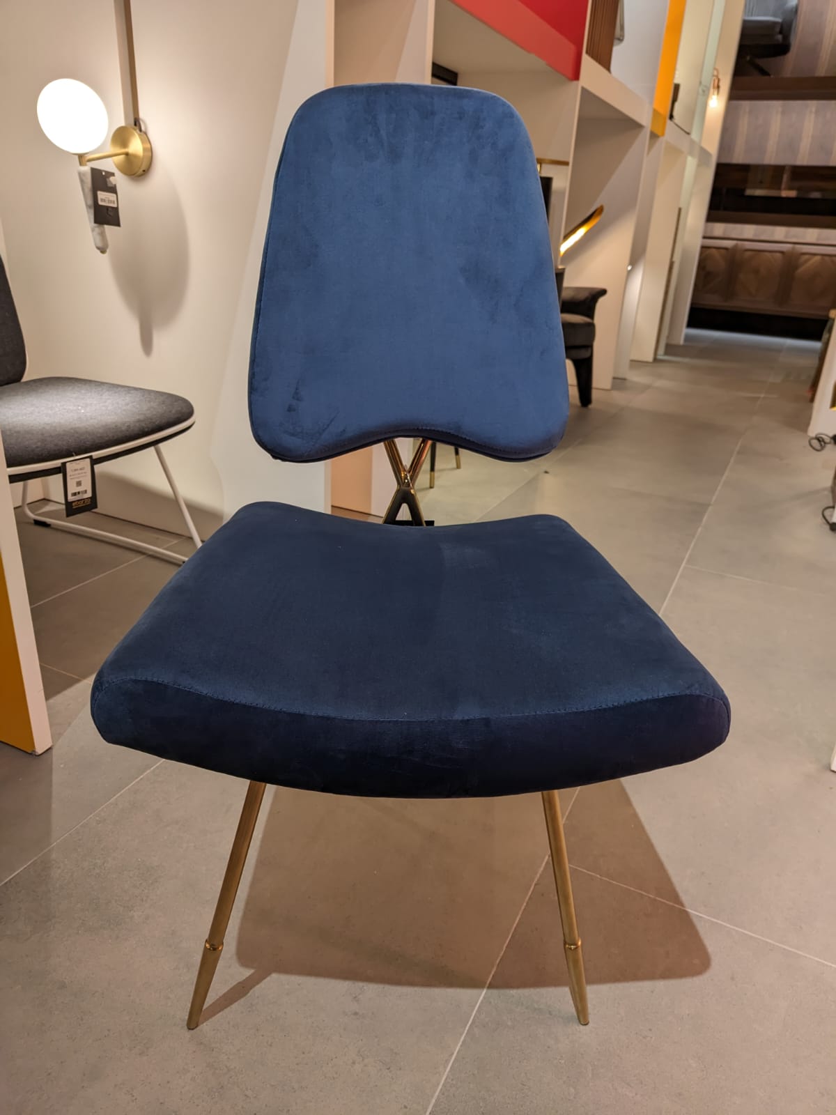 Display of Velletri Cross dining chair by Beacon, showing the modern design and sturdy frame in a showroom setting.