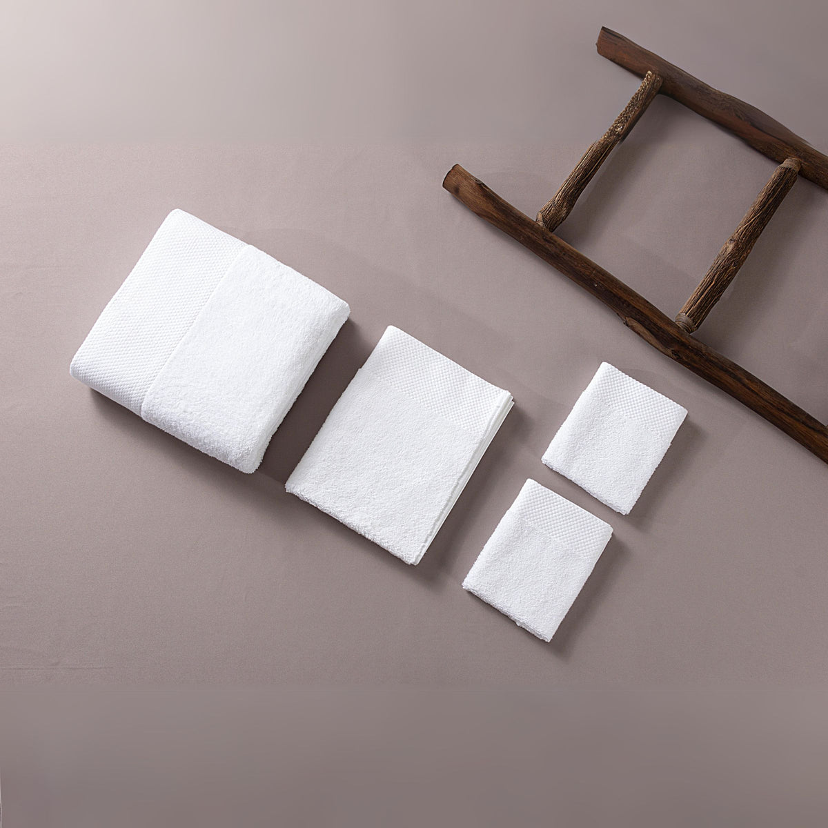 Ebbrza Dobby Border Towel Set from BEACON, soft cotton towels with intricate border design, ideal for bath or beach use.