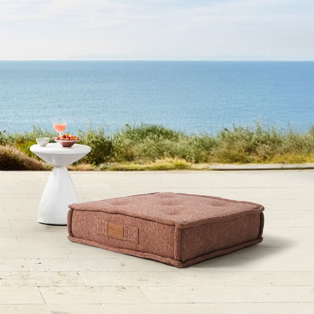 Orange La Concha pouf by BEACON with compressed foam, showcasing its rounded shape and textured fabric surface.