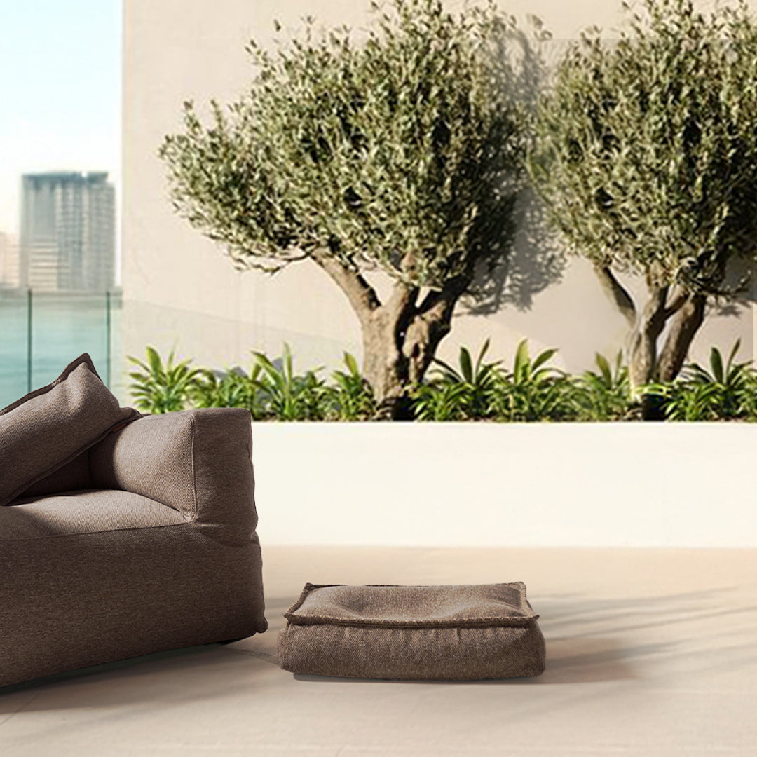 Small brown pet bed pouf by BEACON, designed for comfort, with soft fabric and cushioned interior for pets.