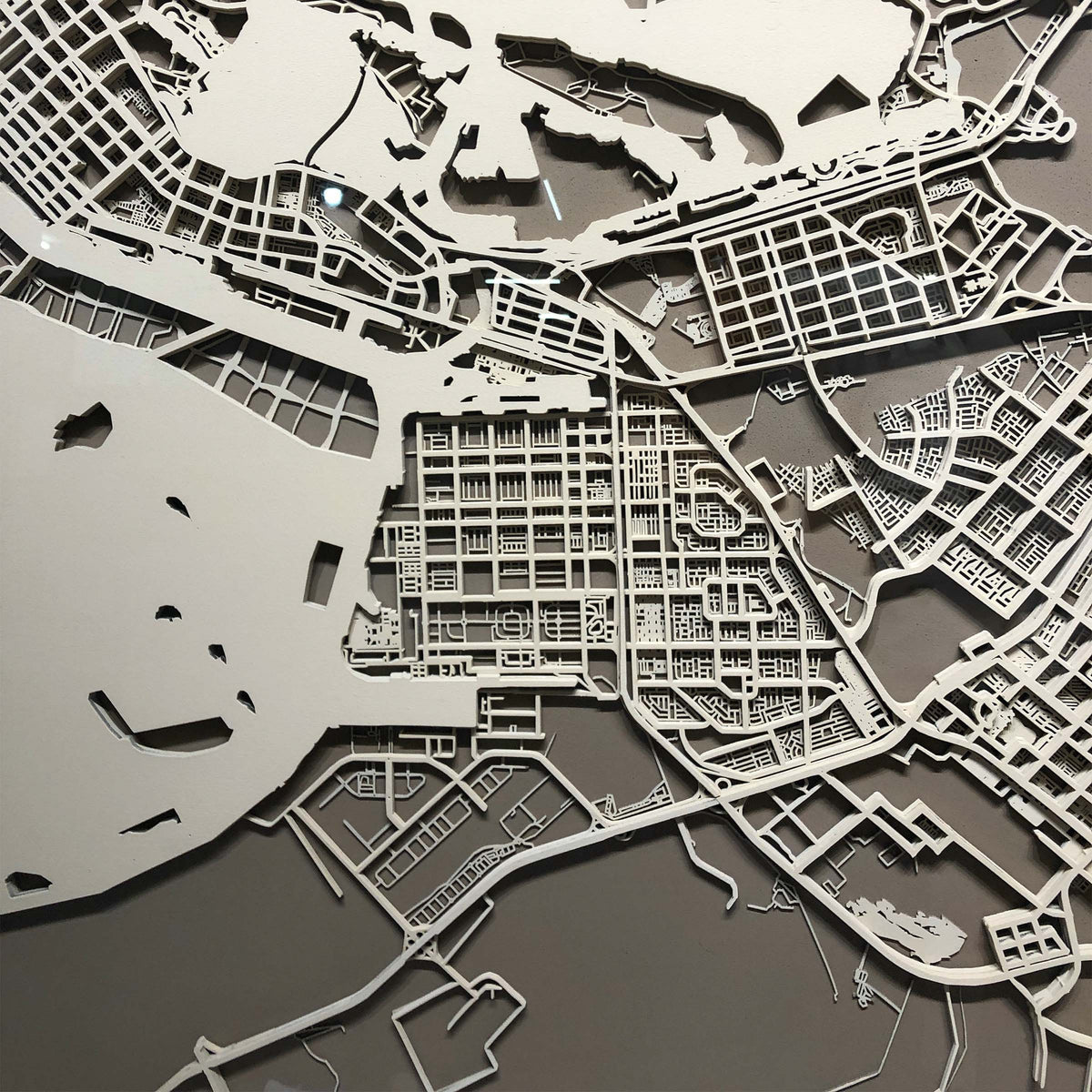 Handmade Abu Dhabi map painting by BEACON, 120x120 cm, detailed artwork displayed on canvas in a natural setting.