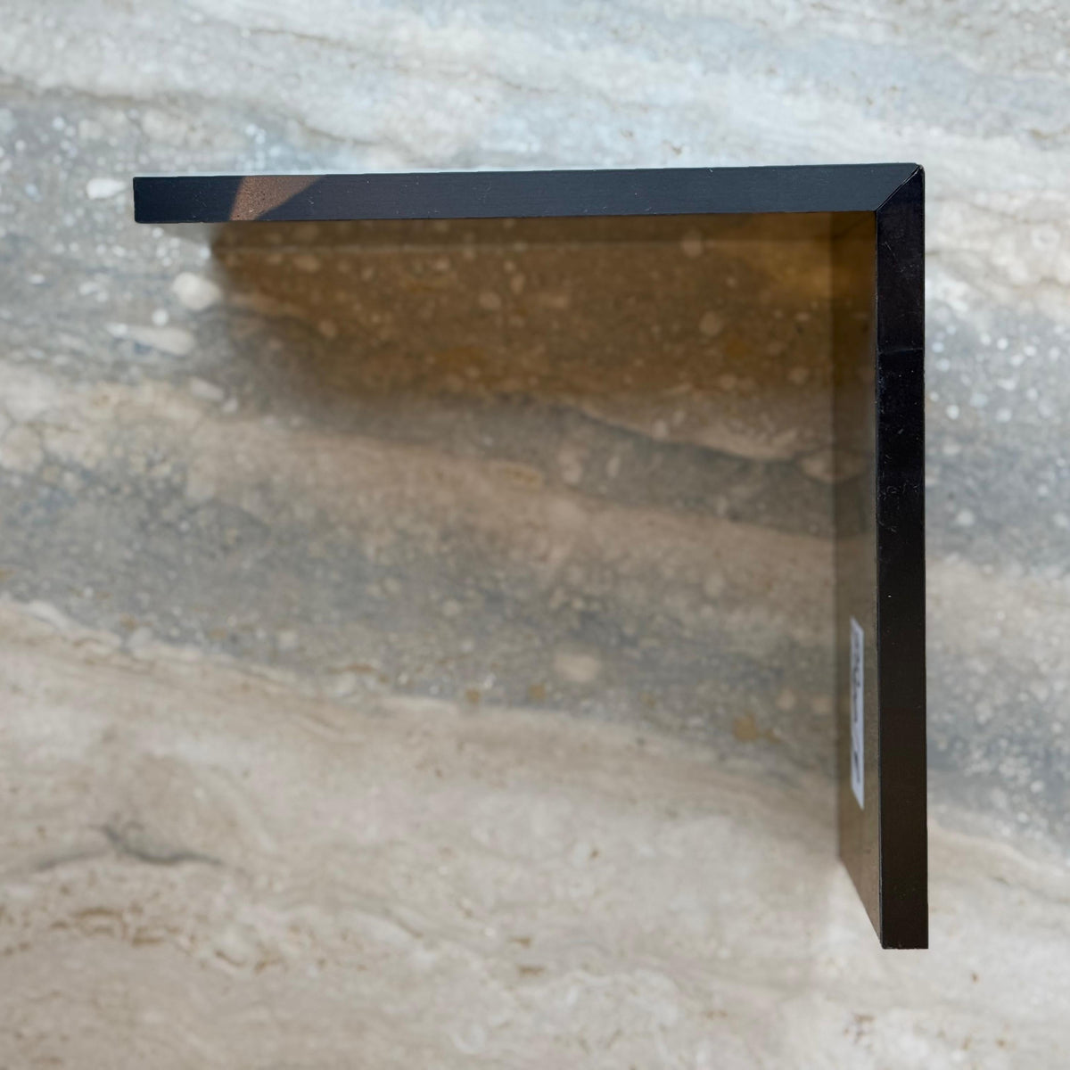 Black R0 10cm external corner skirting accessory by BEACON for wall panels and profiles, shown installed on corner.
