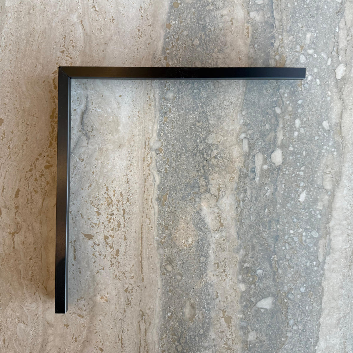 Black R0 2.5cm internal corner accessory for wall panels and profiles, designed by BEACON, shown in close-up on a wall.