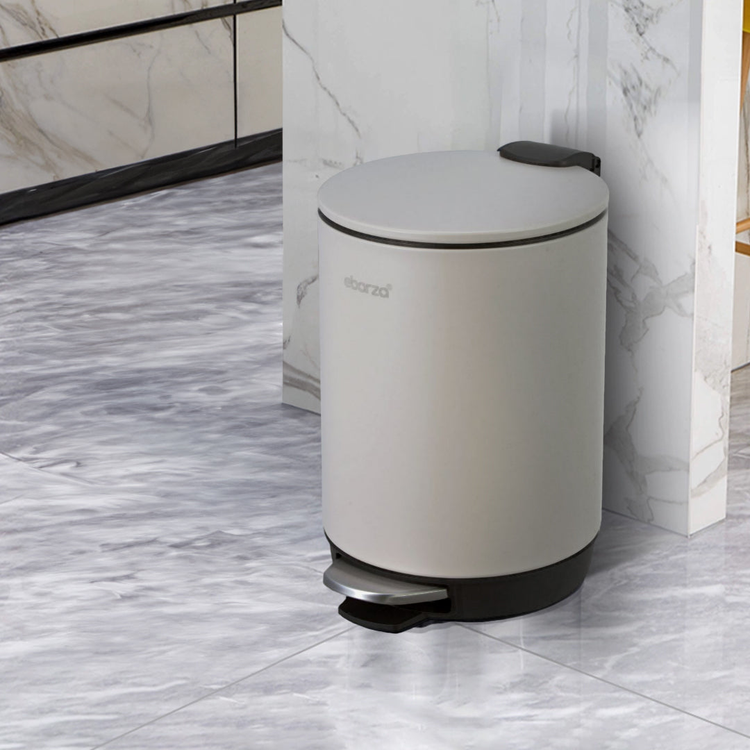 Gray round high basement step trash can by BEACON, bathroom accessory with a foot pedal for hands-free disposal.