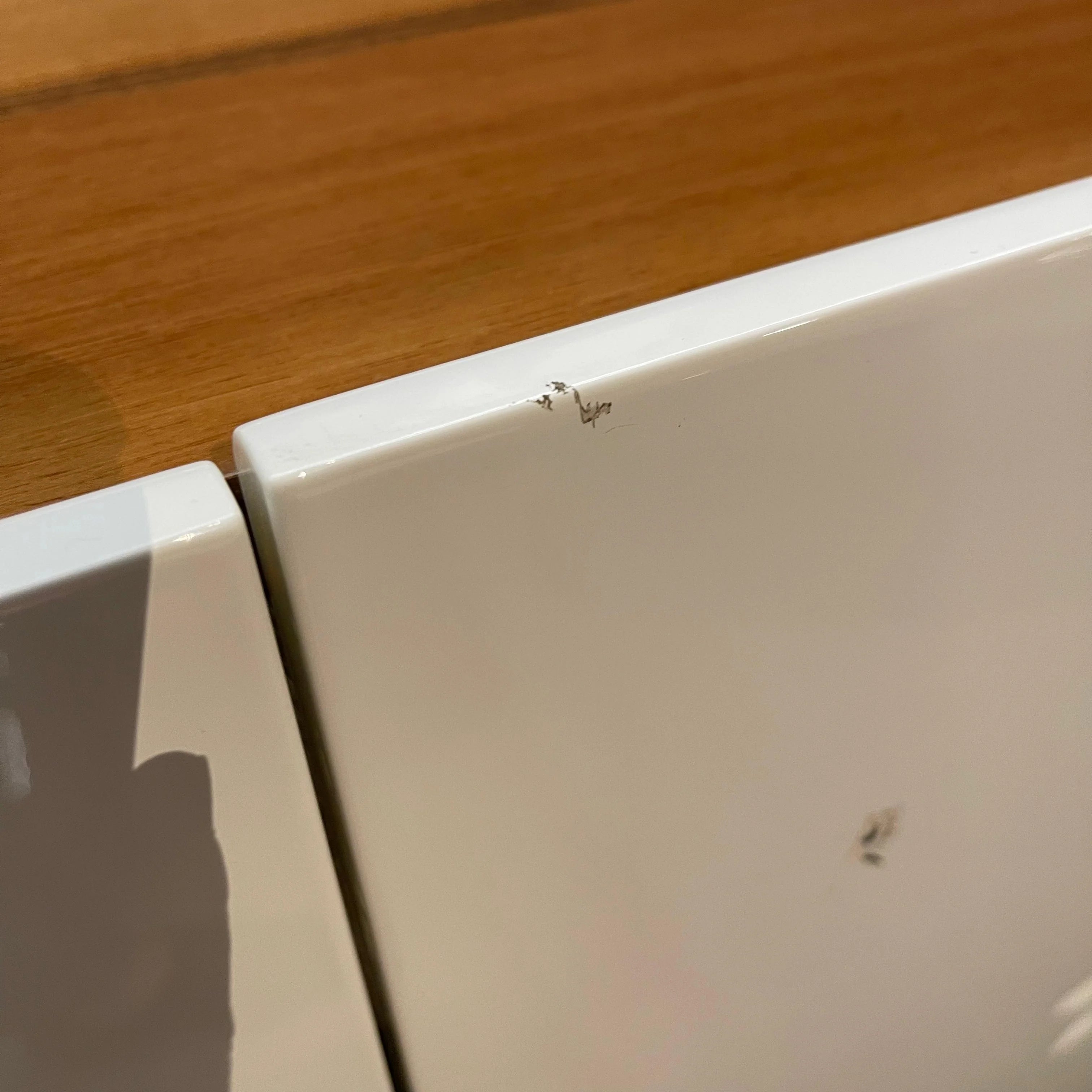 Close-up of a white appliance with a wooden surface in the background