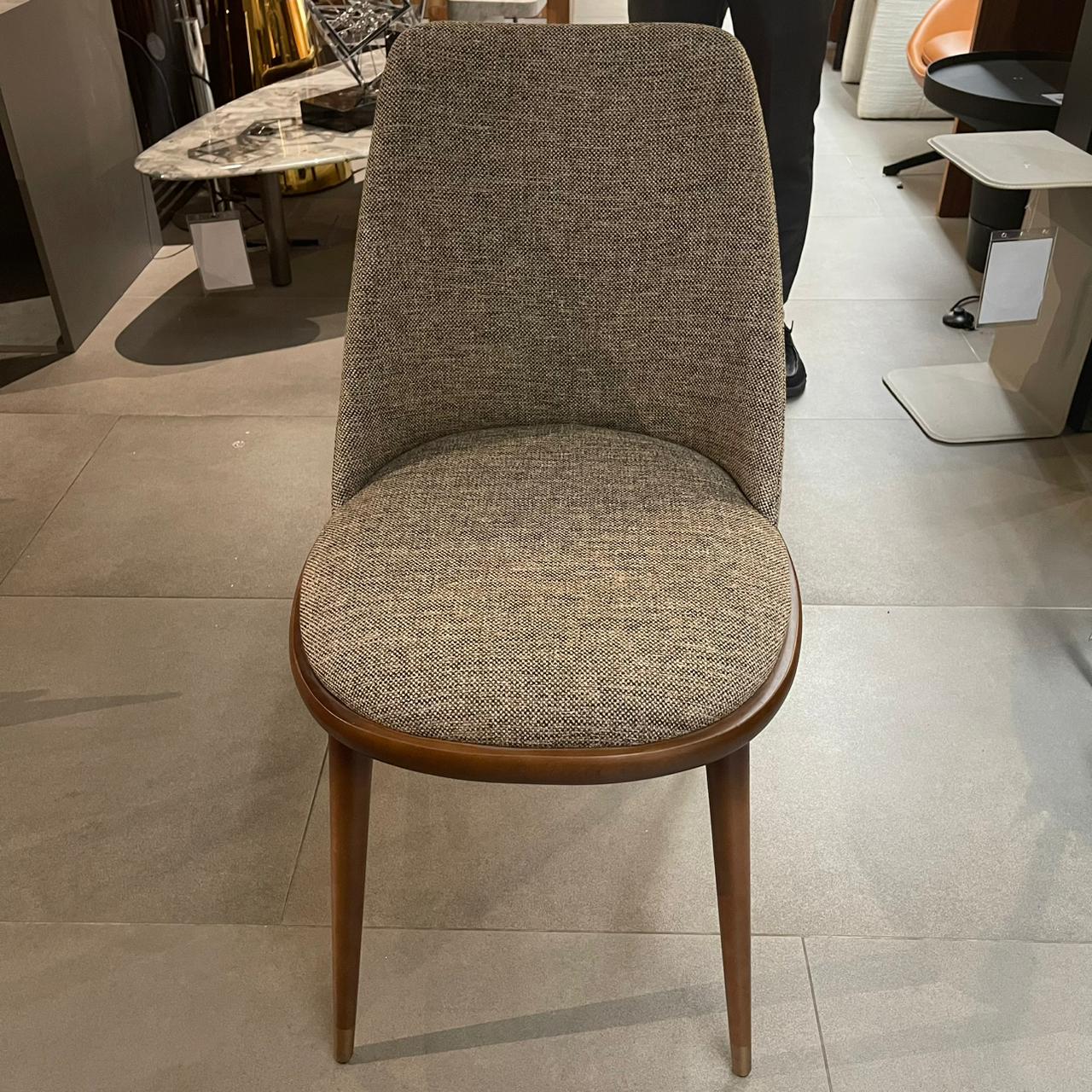 YOL LIVING Pena dining chair display model with wooden legs and upholstered seat, showcasing modern dining room furniture.