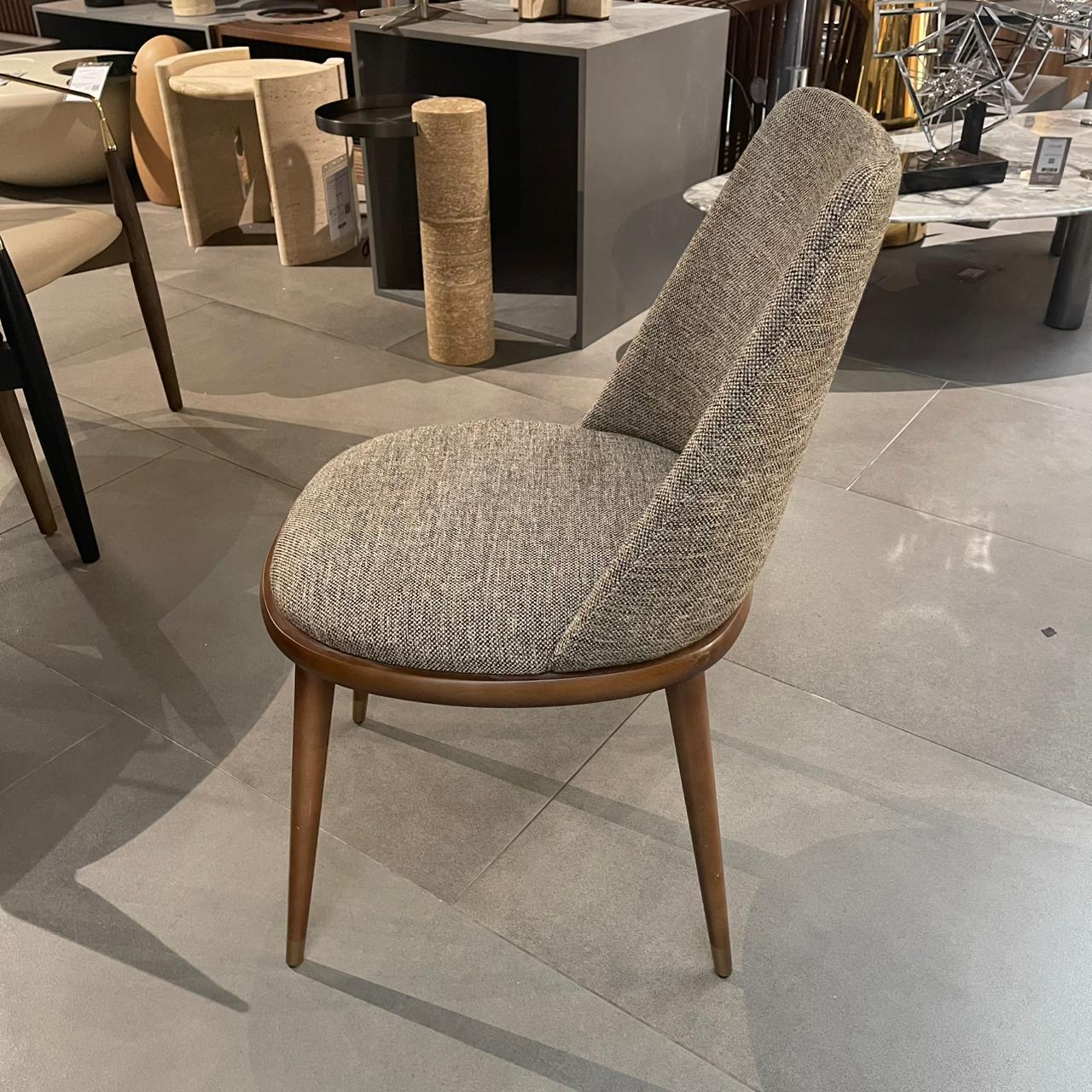 Display of a Pena YAS dining chair by YOL LIVING, showcasing its modern design and wooden frame.