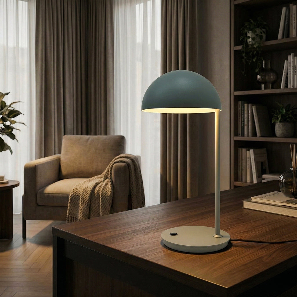 BEACON Eris table lamp with sleek modern design, black finish, and adjustable arm on a wooden desk surface.