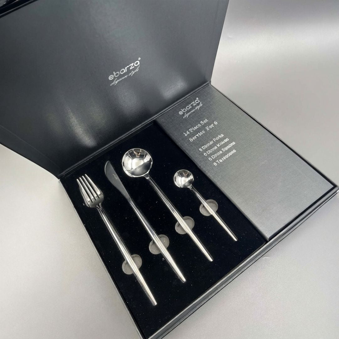 Obsidian 24-piece shiny silver cutlery set by BEACON, includes forks, knives, spoons, and teaspoons arranged on a table.