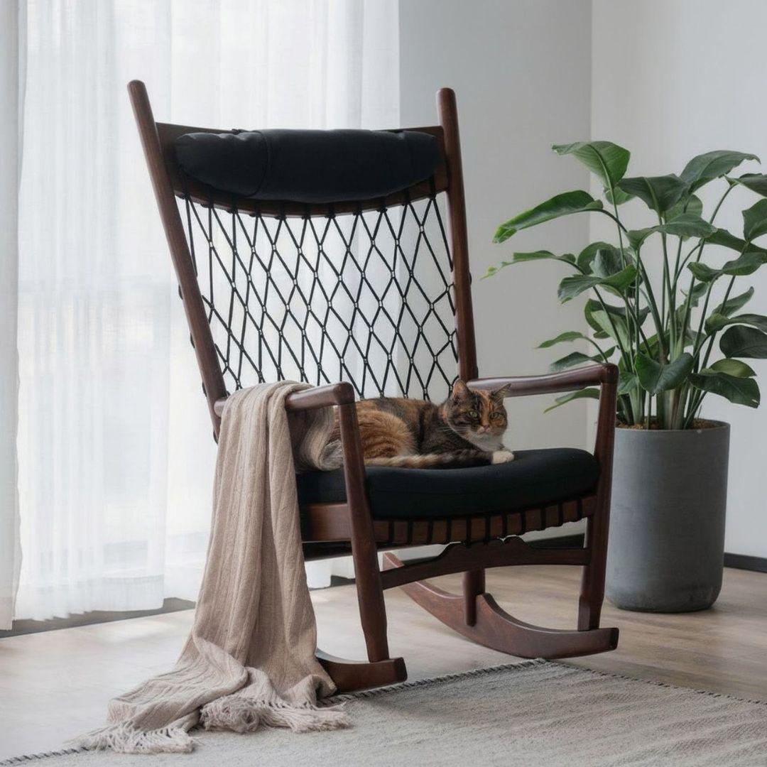 a cat sitting on a rocking chair with blanket