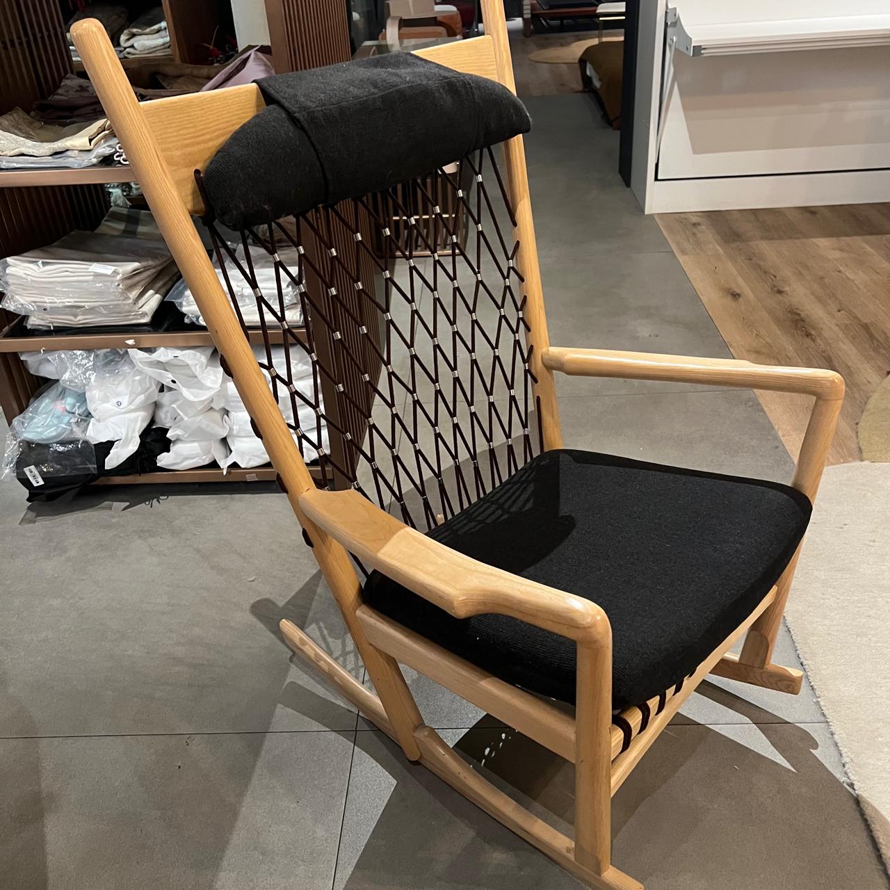 Solid wood and cord lounge chair display item by RUDI, featuring a modern design with a wooden frame and woven cord seating.