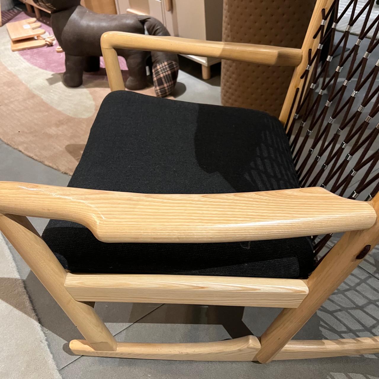 Solid wood and cord lounge chair display model from RUDI, showcasing a modern design with wooden frame and woven cord seating.