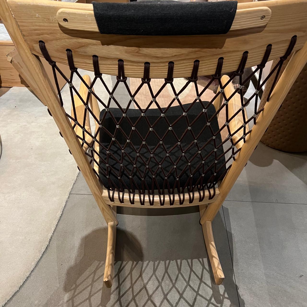Solid wood and cord lounge chair display item by RUDI with a modern design, featuring a wooden frame and woven cord seating.