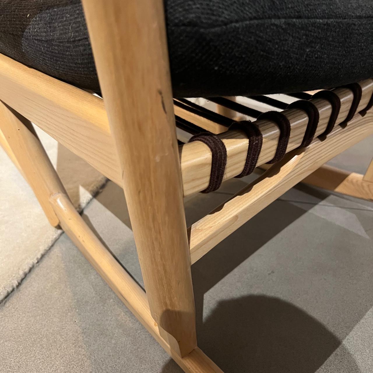 Display of RUDI solid wood and cord lounge chair with a sleek, modern design, showcasing the chair’s wood frame and woven cord seat.
