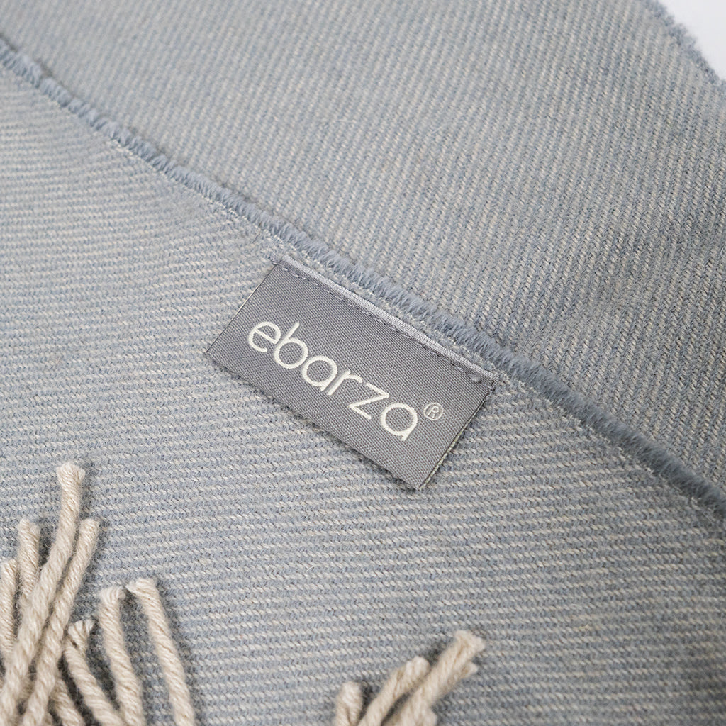 BEACON wool throw blanket in natural colors, soft and cozy with woven texture, perfect for relaxing on a sofa or bed.