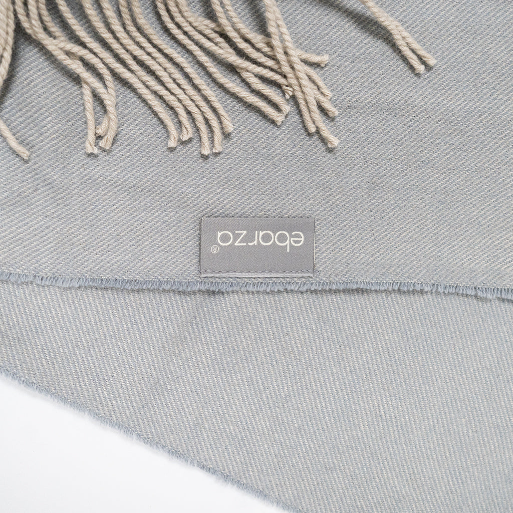 BEACON Fjord Wool Throw Blanket DR-THW15 displayed folded on a cozy sofa, showcasing soft, textured wool fabric for warmth and comfort.