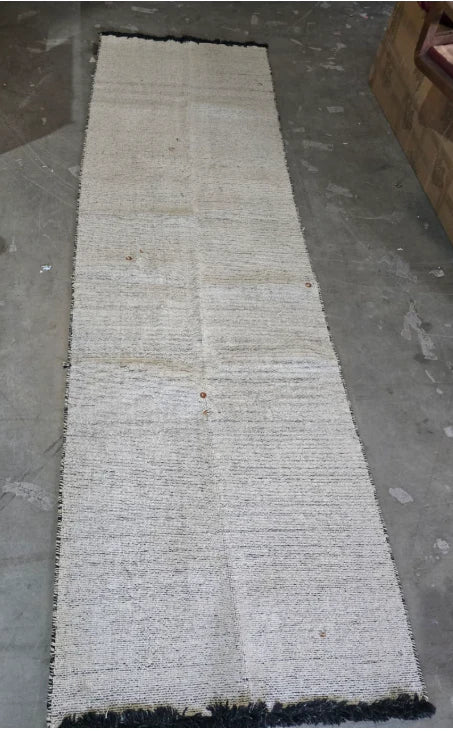 Display image of a 90x300 cm hand-woven ivory and black wool rug by Javi, showcasing its long rectangular design.