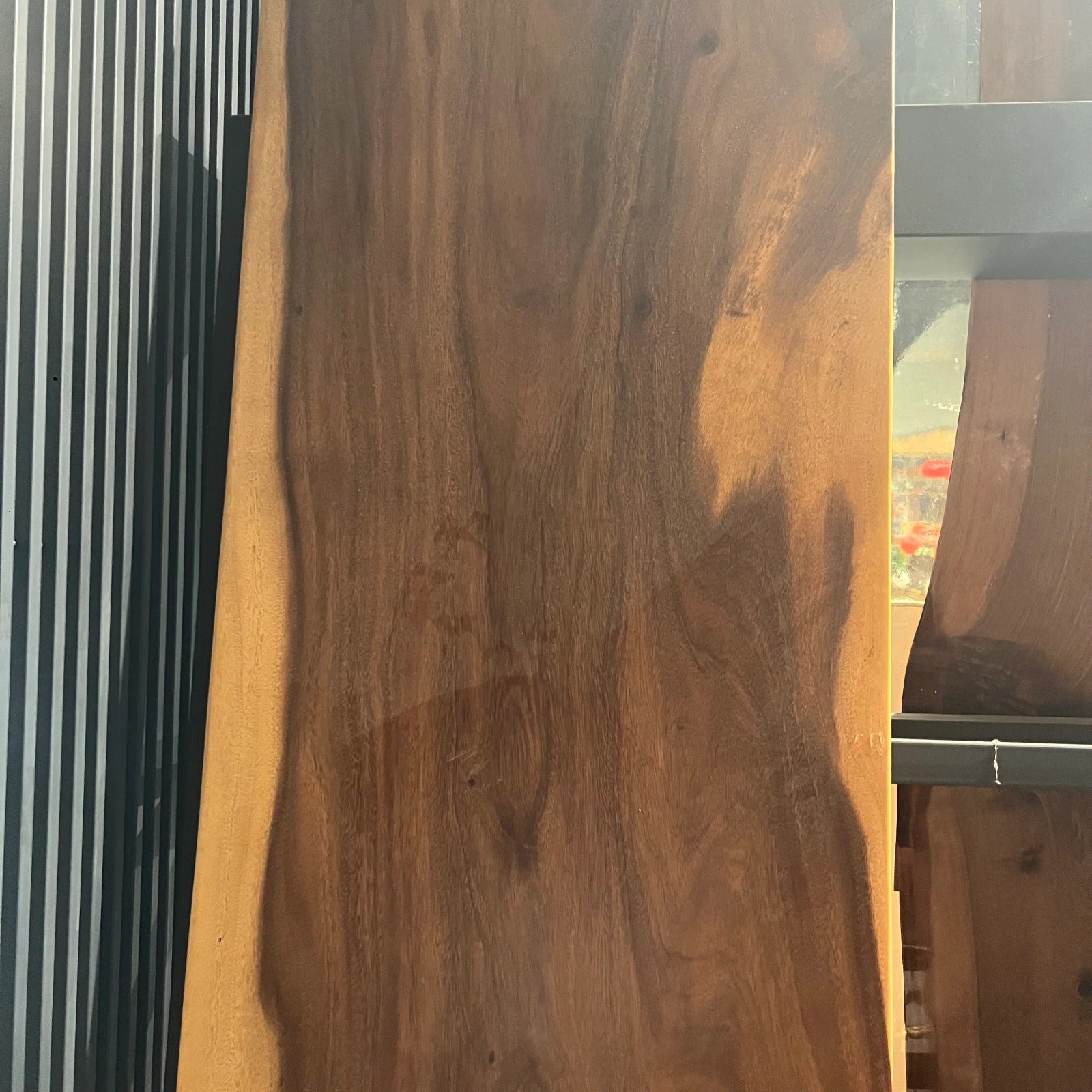 Live edge dining table by SANCREA, 275 inches long, with natural wood finish, displayed as a showroom sample.