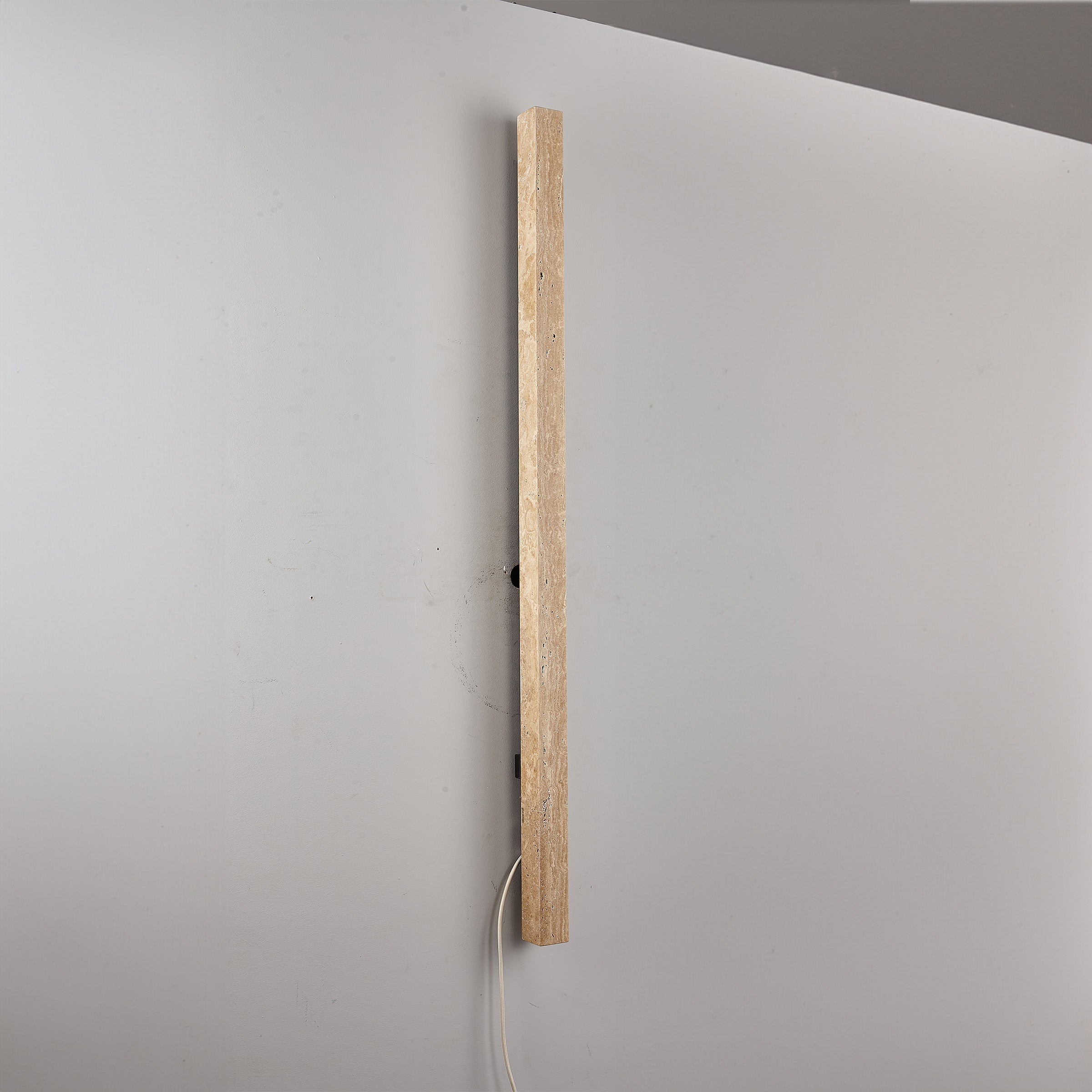Beige natural travertine marble wall lamp by BEACON, featuring a sleek design with warm illumination for modern interiors.