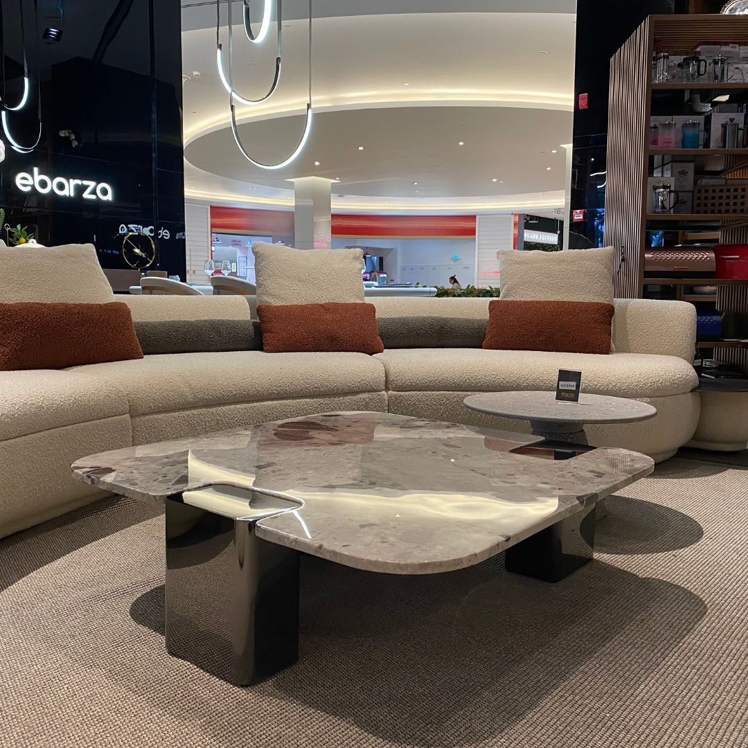 Modern coffee table with a natural stone top and stainless steel legs, featuring a sleek design for contemporary living rooms.