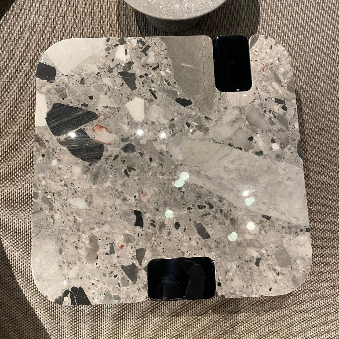 Modern coffee table with a natural stone top and stainless steel legs, providing a sleek and stylish addition to living rooms.