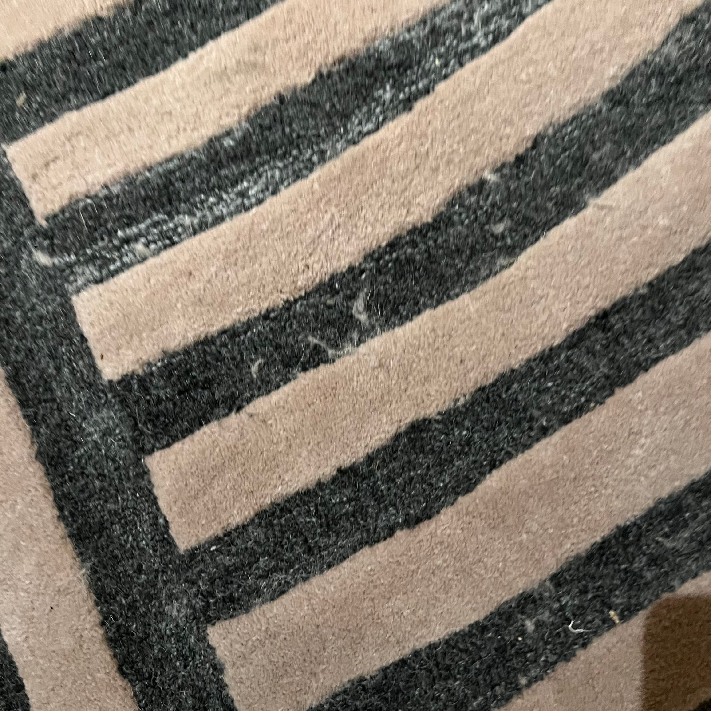 Display item of a 450x300 cm beige and brown wool rug by Javi, showcasing its intricate woven pattern and soft texture.
