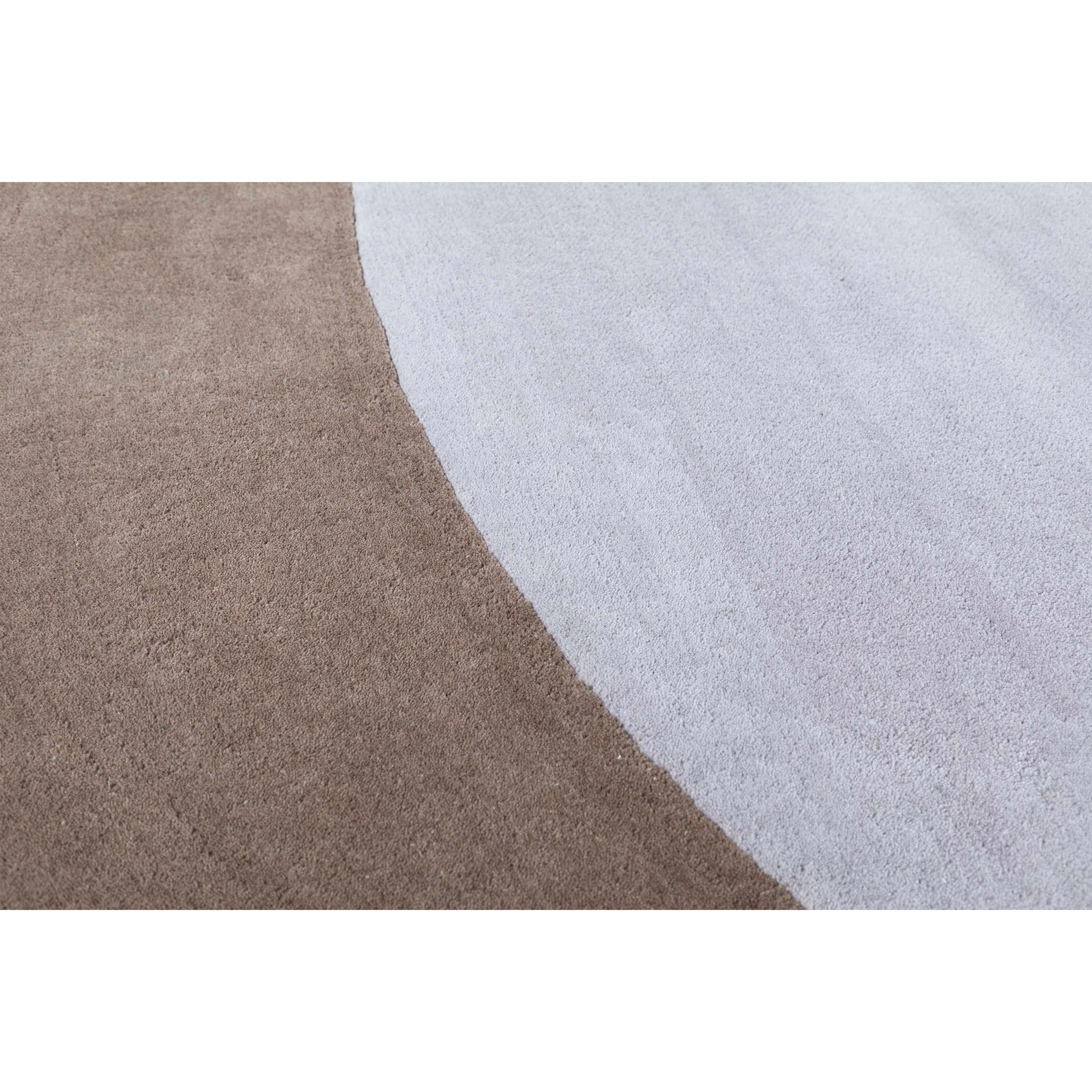 Round wool rug in beige and brown with a 500x350 cm size, featuring a soft textured surface and intricate pattern.