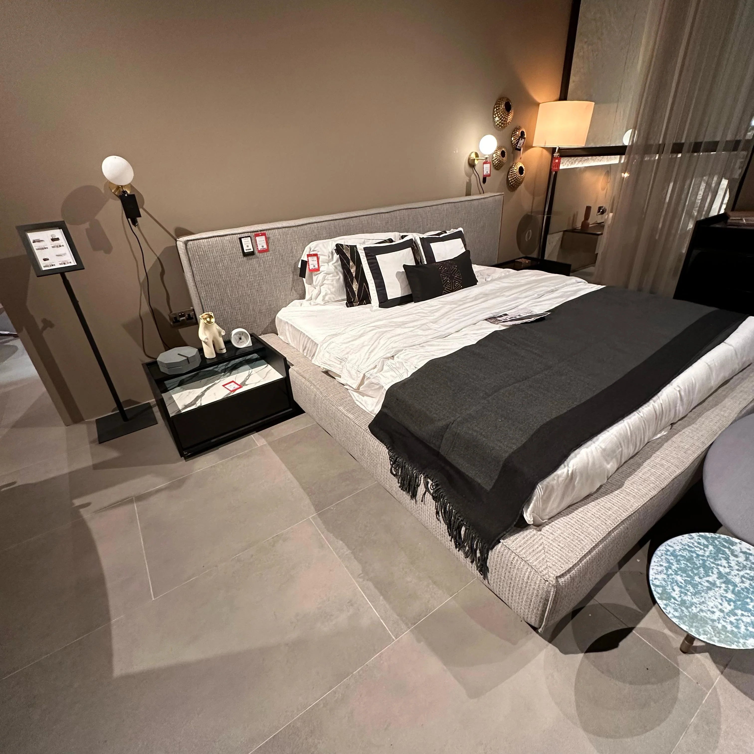 Display of the YOL LIVING Grey King Bedstead in a showroom setting, showcasing its sturdy frame and modern design.