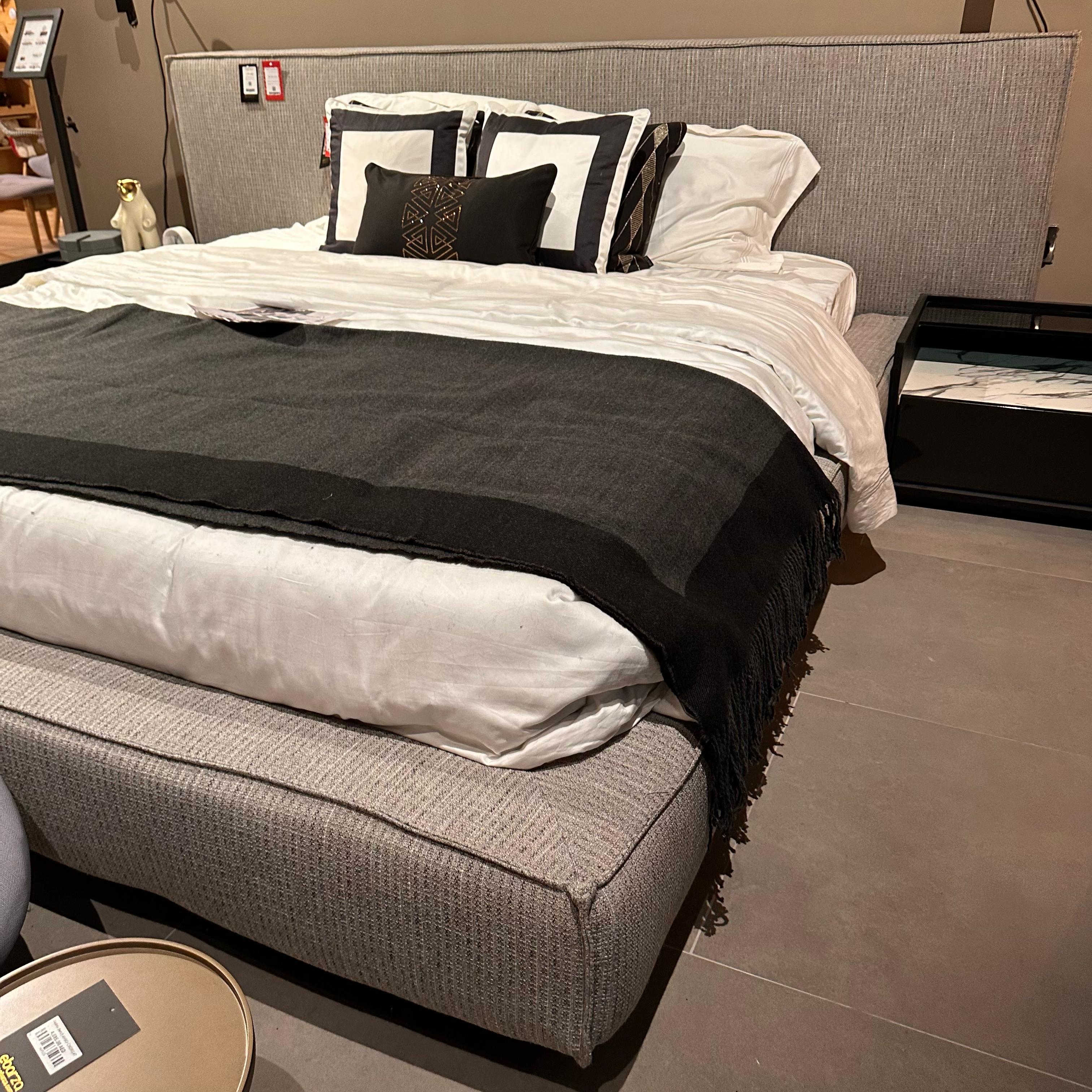 Display of a grey king bedstead from YOL LIVING, showcasing the sturdy frame and elegant design in a showroom setting.