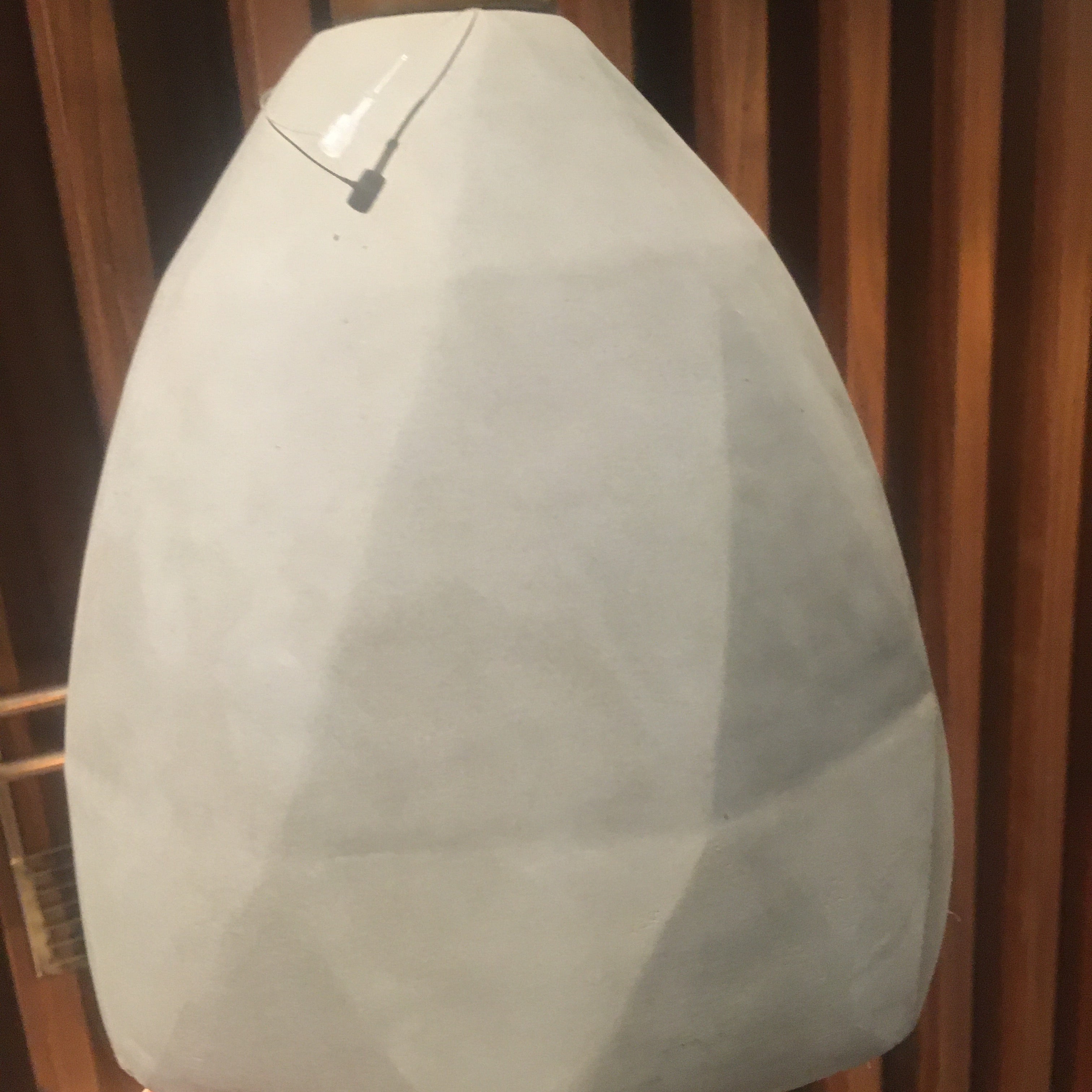 Large convex concrete and wood lamp display item by Beacon, showcasing a modern, textured design with a curved shape and natural finish.