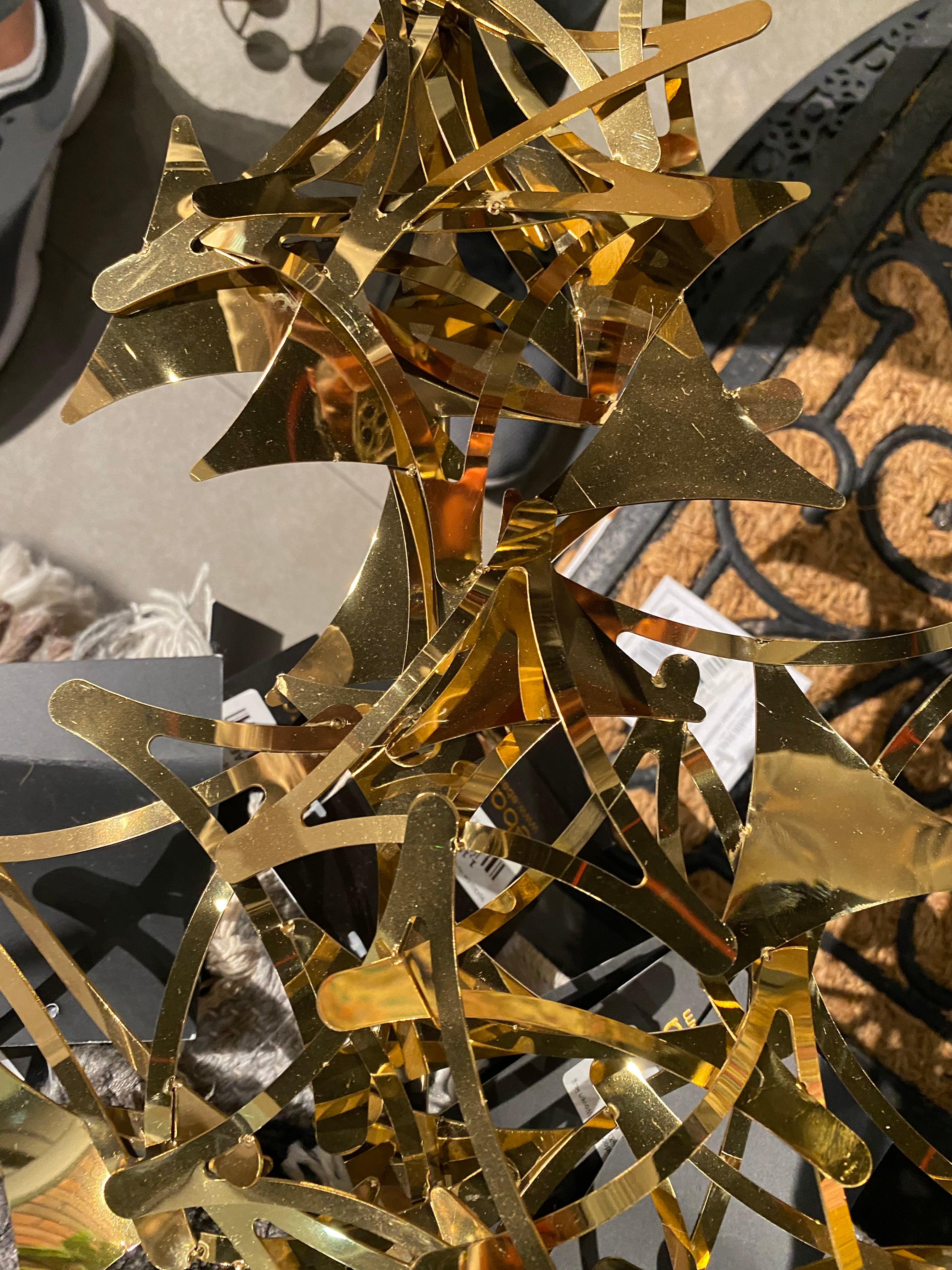 Golden stars handcrafted stainless steel artwork display item by Beacon, featuring intricate star designs on shiny metal surface.