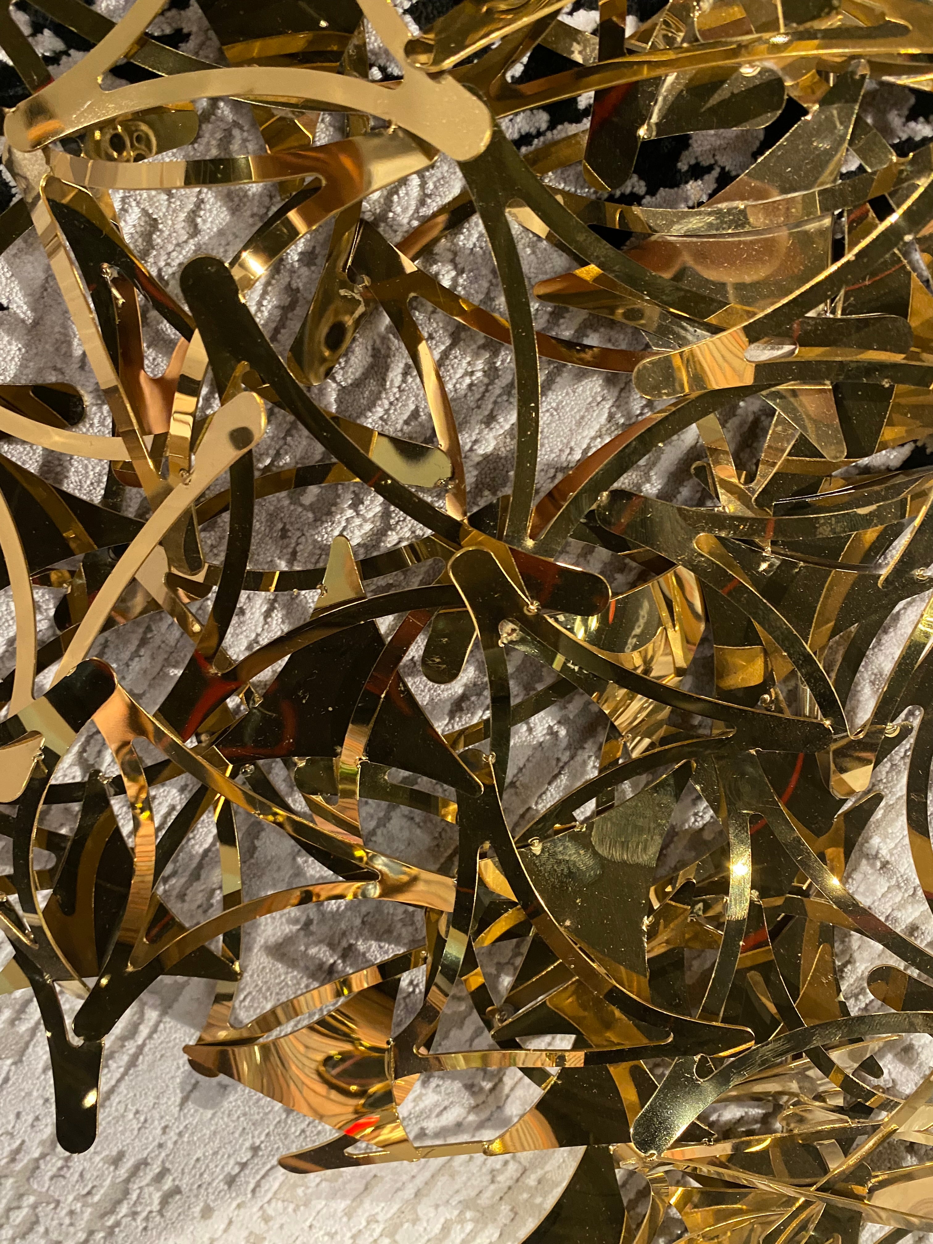 Golden stars handcrafted stainless steel artwork display item by Beacon, featuring intricate star designs on a sleek metal surface.
