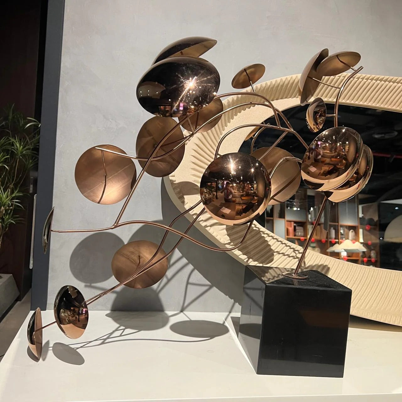 Display item featuring a handcrafted stainless steel table artwork by Life Branch, showcasing intricate metal design.