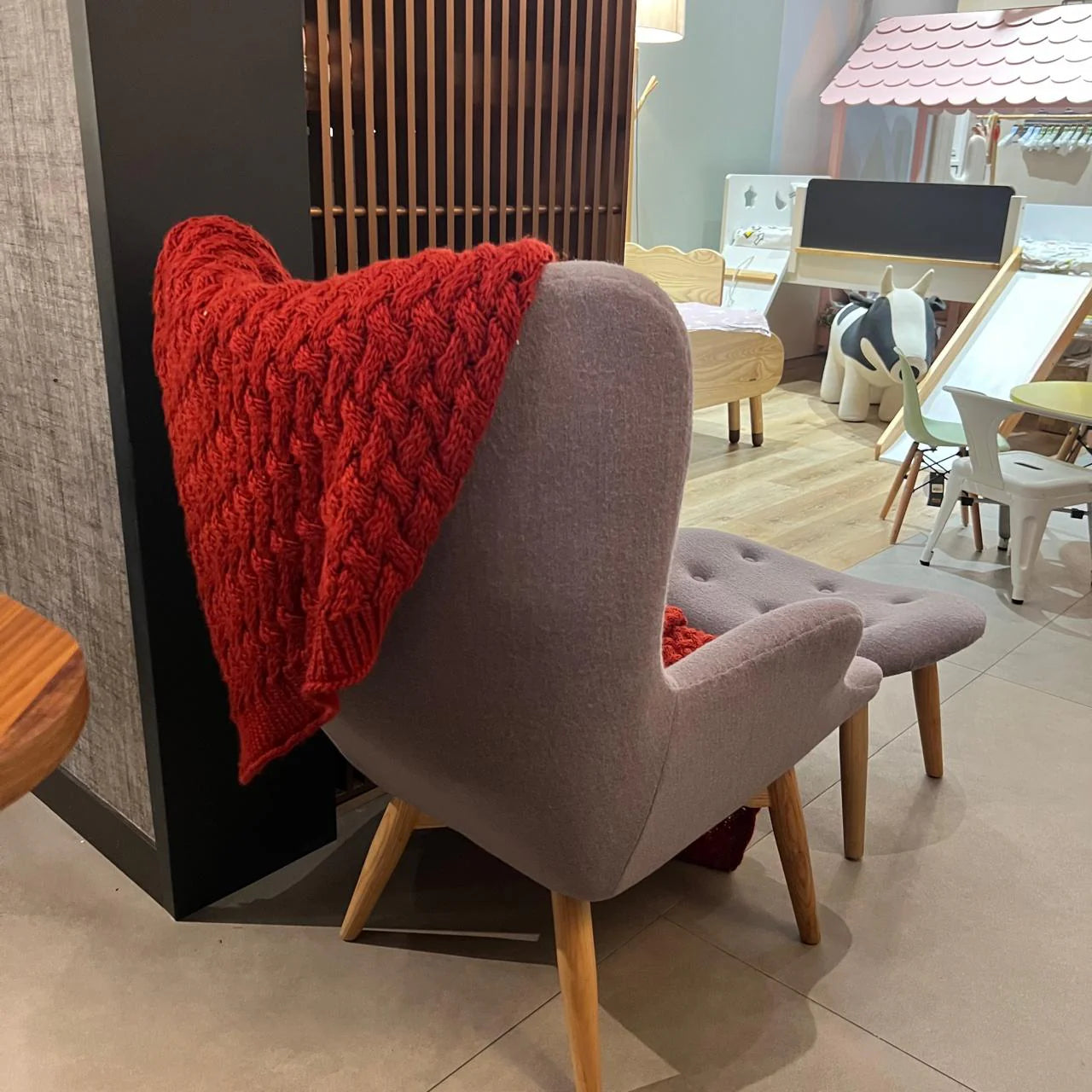 Display item of a Beacon Nakheel lounge chair with matching ottoman, showcasing modern design and neutral fabric upholstery.
