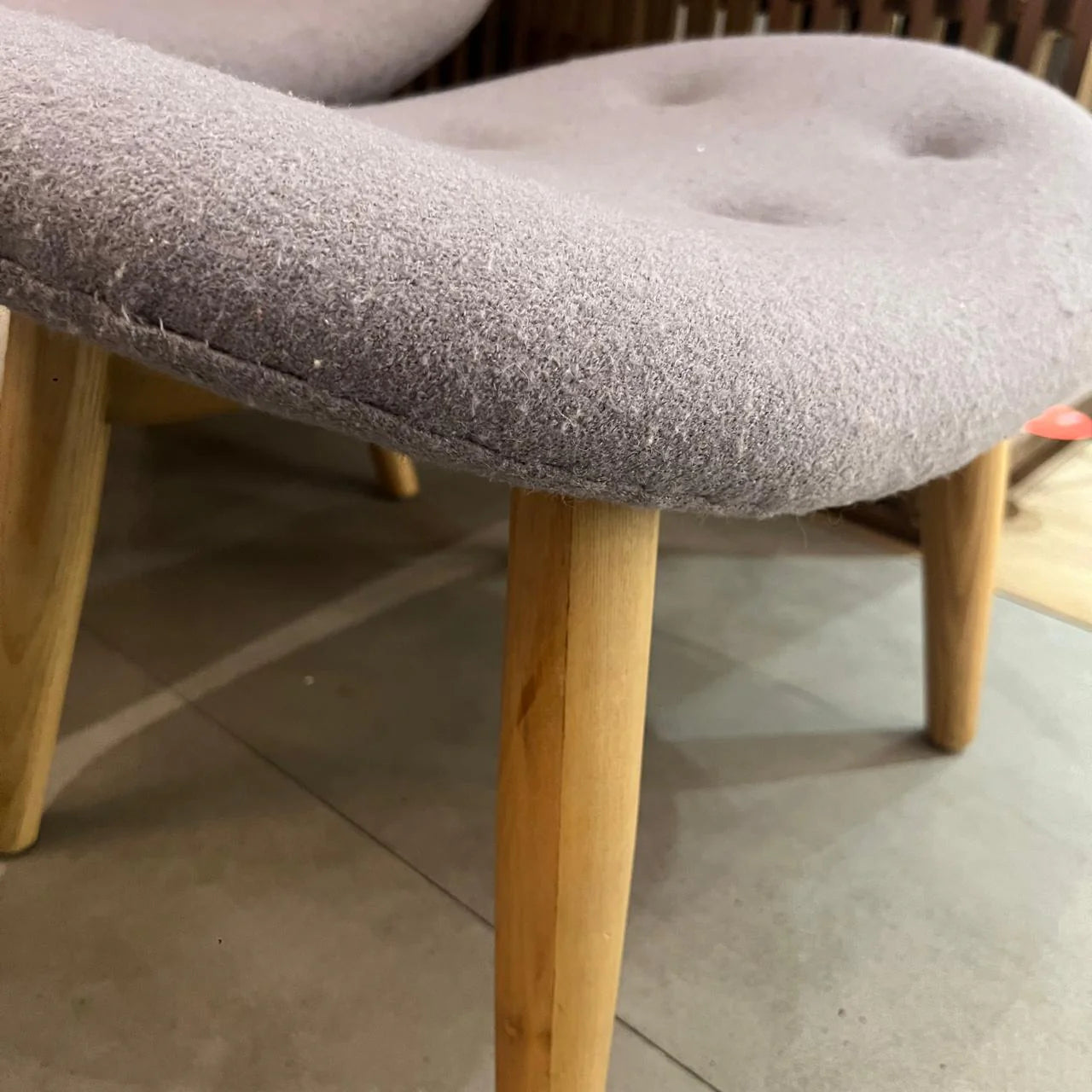 Display of a BEACON lounge chair and matching ottoman, showcasing modern upholstery and sleek design in a stylish setting.