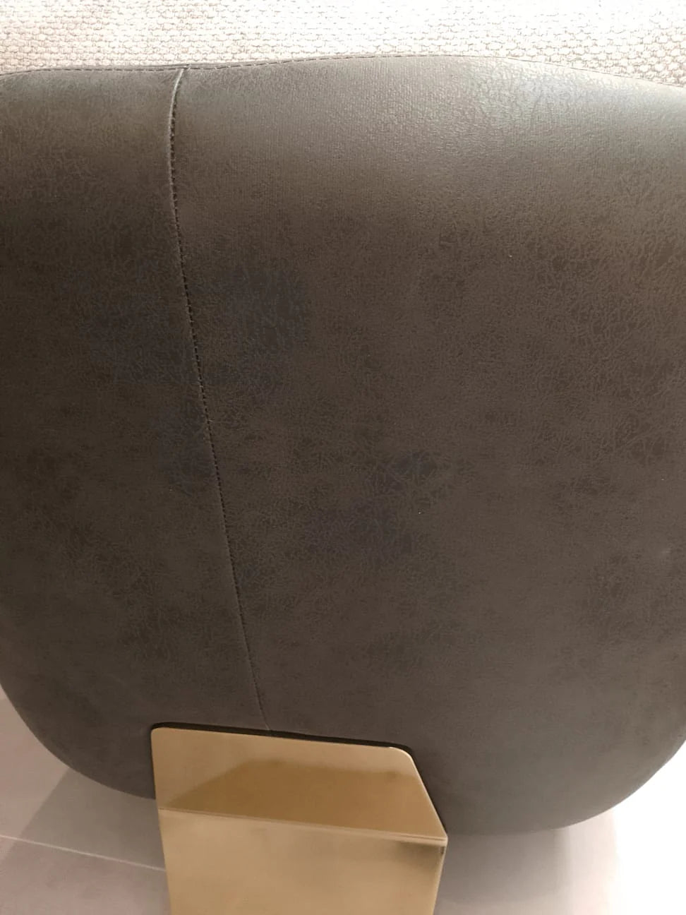 Tesla Armchair display model by SALONI, modern armchair with sleek design and plush upholstery, shown in a showroom setting.