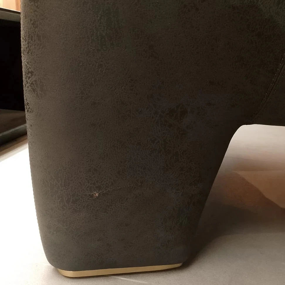 Tesla Armchair display model by SALONI, featuring modern design with plush upholstery and sleek armrests, shown from a side view.