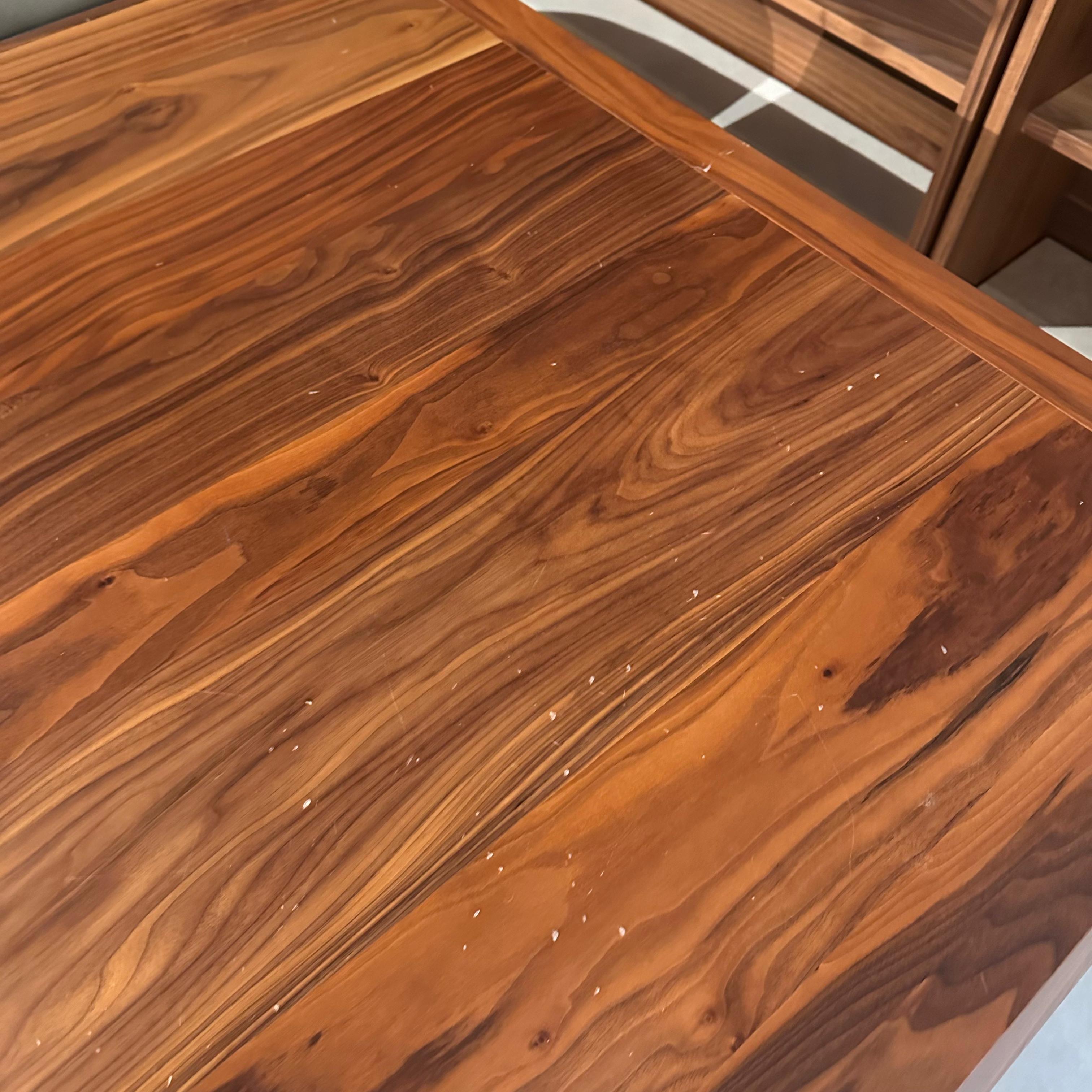 Display piece of the Genova Dining Table by YOL LIVING, showcasing the table's wooden surface and design details.