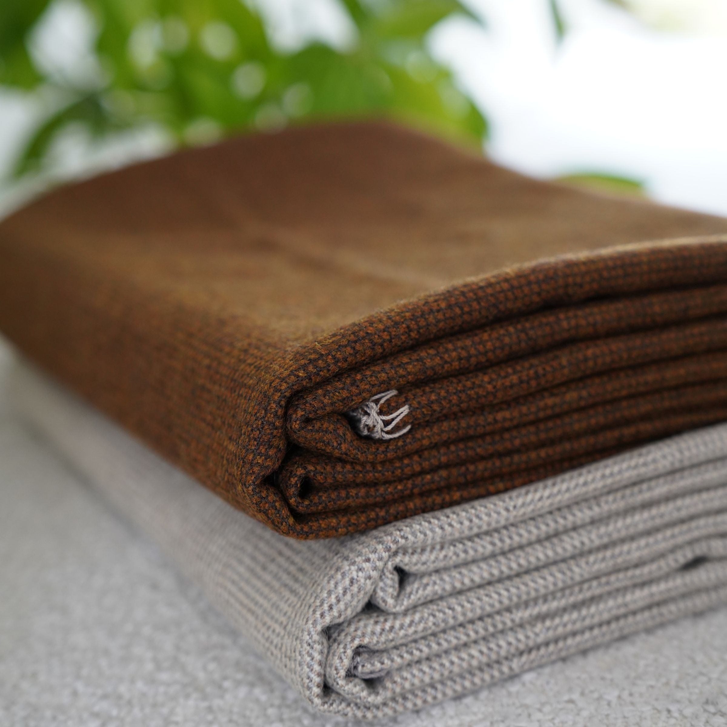 Ebarza Cartier Monochrome Wool Blanket by BEACON, soft gray textured wool blanket laid flat with folded edges.