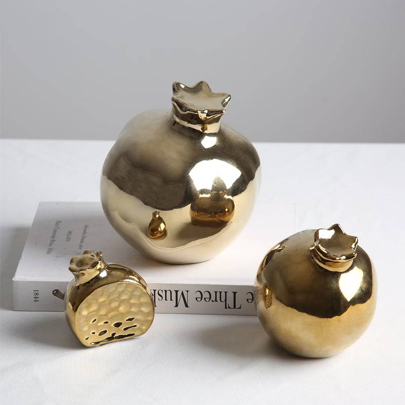 Golden pomegranate home decor figurine by BEACON, decorative gold-colored ornament for stylish interior accents.
